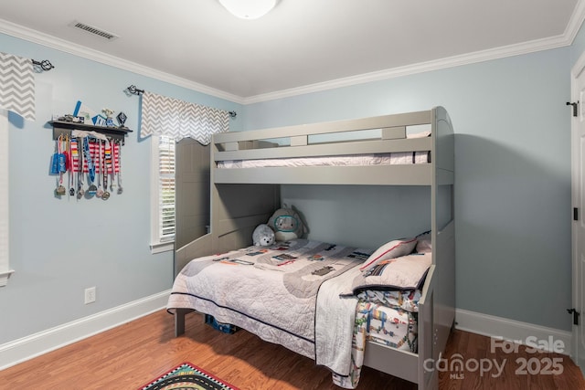 bedroom with hardwood / wood-style floors and crown molding