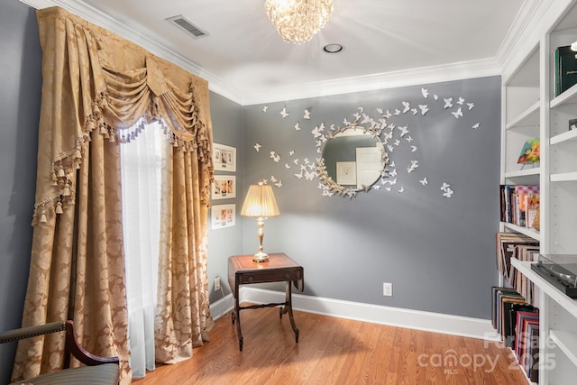 living area with an inviting chandelier, crown molding, and hardwood / wood-style flooring