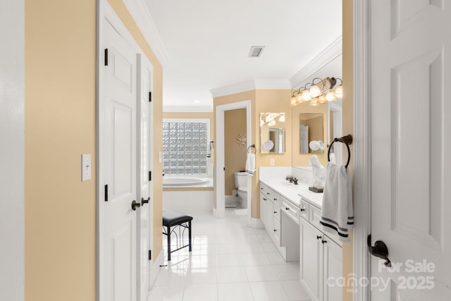 bathroom with ornamental molding, vanity, toilet, tiled tub, and tile patterned floors