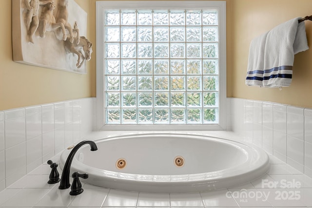 bathroom with a wealth of natural light and tiled bath