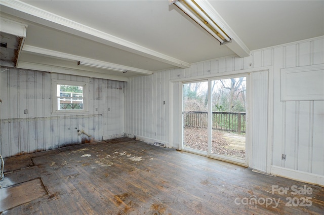 unfurnished room featuring beam ceiling