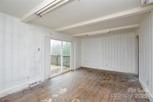 empty room featuring dark hardwood / wood-style floors and beam ceiling