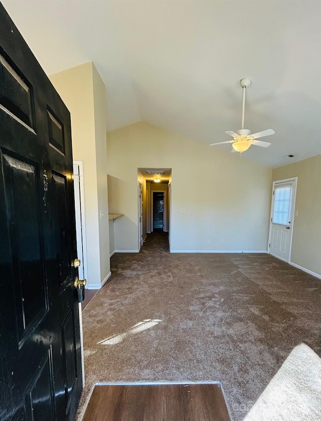 interior space featuring lofted ceiling, visible vents, carpet flooring, ceiling fan, and baseboards