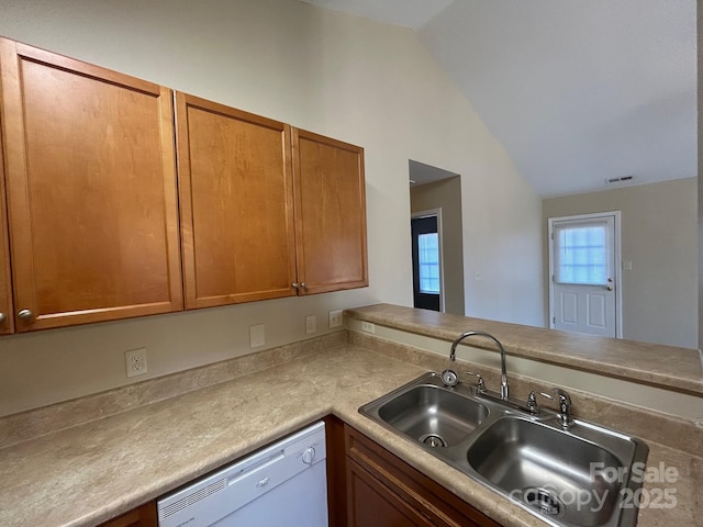 kitchen featuring white dishwasher, a sink, visible vents, vaulted ceiling, and brown cabinets