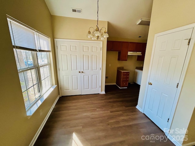 interior space featuring a chandelier, dark wood-style flooring, visible vents, and baseboards