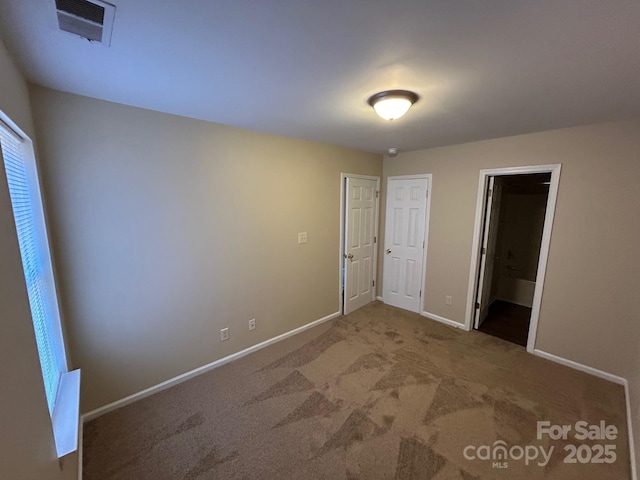 unfurnished bedroom featuring baseboards, visible vents, and carpet flooring