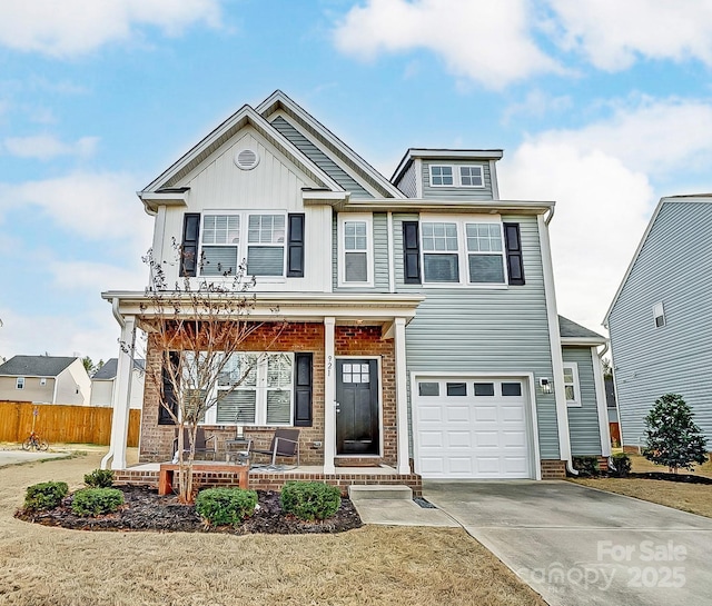 view of front facade featuring an attached garage, covered porch, fence, driveway, and board and batten siding