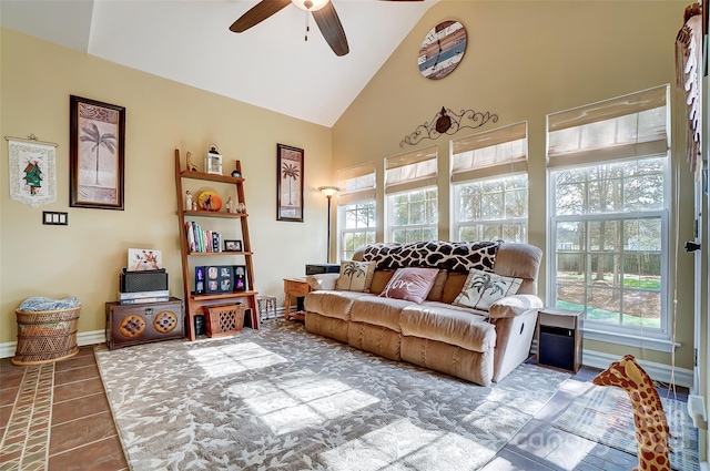 tiled living room with ceiling fan, high vaulted ceiling, and baseboards