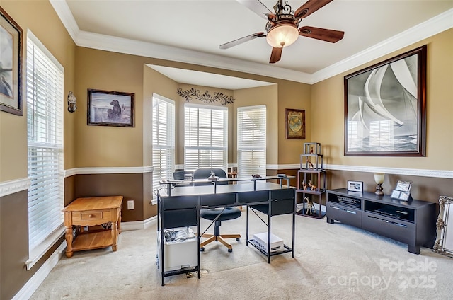 home office featuring ceiling fan, baseboards, crown molding, and light colored carpet