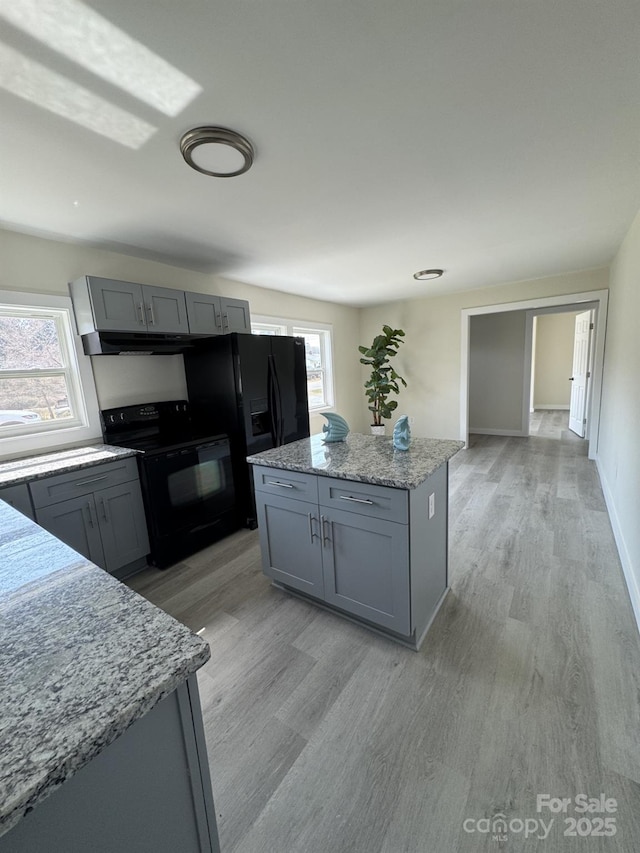 kitchen with black / electric stove, light wood-style floors, and gray cabinets