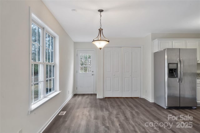 interior space with white cabinetry, decorative light fixtures, wood-type flooring, and stainless steel refrigerator with ice dispenser