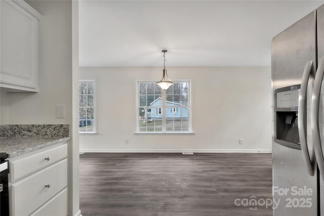 kitchen featuring dark wood-type flooring, white cabinetry, light stone counters, stainless steel fridge with ice dispenser, and decorative light fixtures