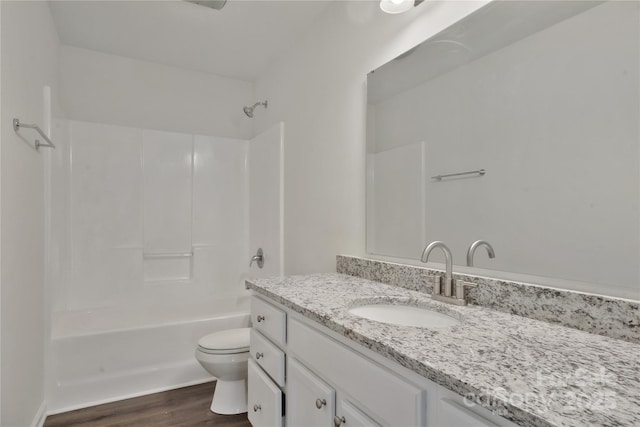 full bathroom featuring hardwood / wood-style flooring, vanity, toilet, and tub / shower combination