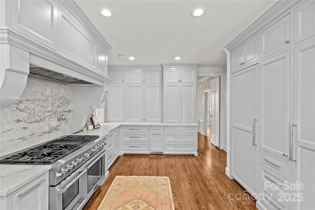 kitchen featuring range with two ovens, recessed lighting, white cabinets, light wood-type flooring, and tasteful backsplash