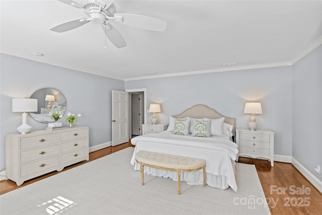 bedroom featuring crown molding, baseboards, and wood finished floors