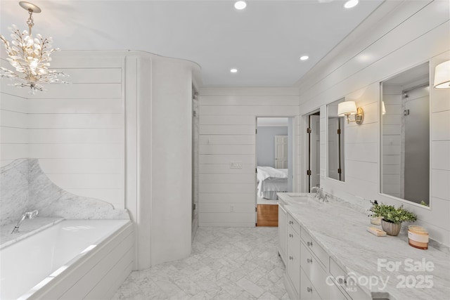 bathroom with recessed lighting, an inviting chandelier, connected bathroom, vanity, and a bath