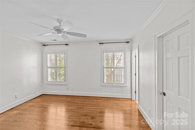 spare room with crown molding, light wood finished floors, visible vents, a ceiling fan, and baseboards