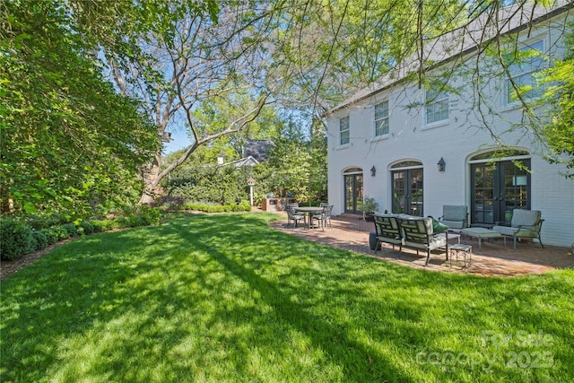 view of yard with a patio, french doors, and an outdoor living space