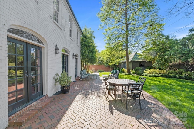 view of patio featuring french doors, fence, and outdoor dining area