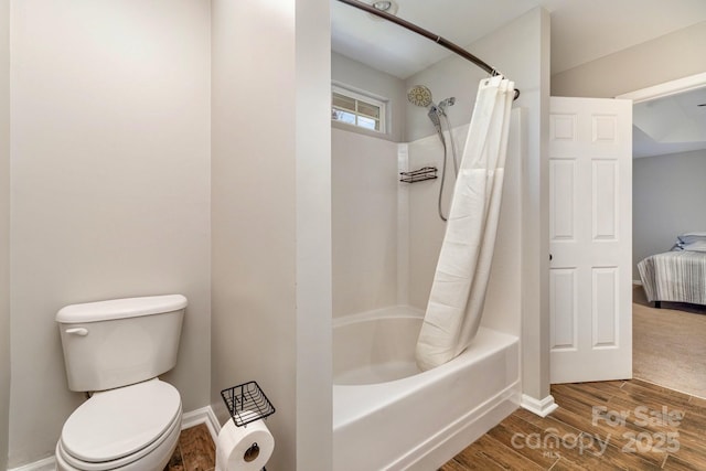 bathroom featuring hardwood / wood-style flooring, shower / bath combo, and toilet