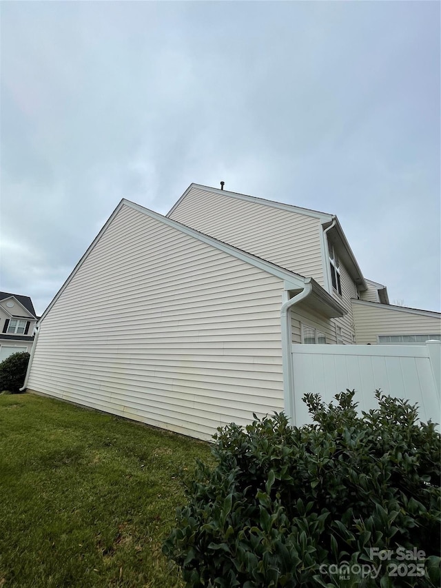 view of side of home with a yard