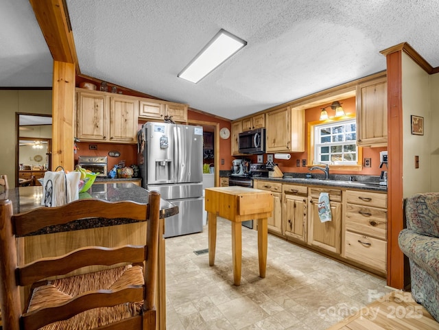 kitchen featuring appliances with stainless steel finishes, dark countertops, vaulted ceiling, and a textured ceiling