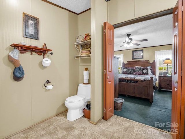 bathroom with a textured ceiling, a ceiling fan, toilet, and crown molding