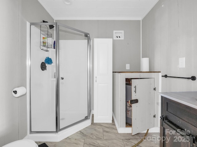 bathroom with a stall shower, marble finish floor, crown molding, and vanity