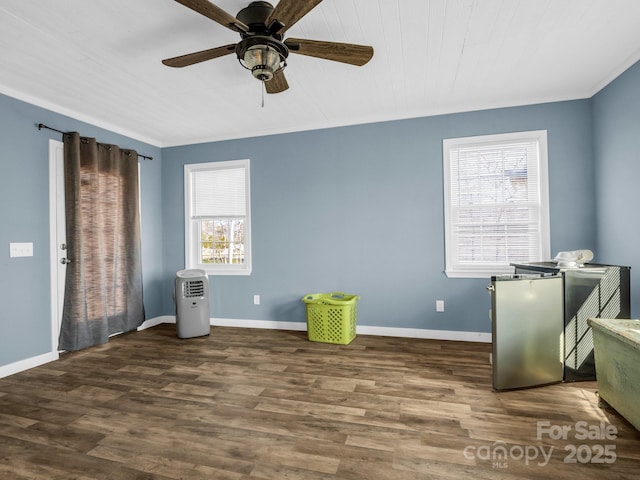 interior space featuring ceiling fan, crown molding, wood finished floors, and baseboards