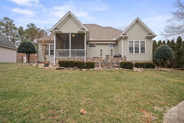 ranch-style house featuring a sunroom, a front lawn, and roof with shingles