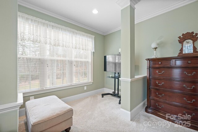 sitting room featuring carpet flooring, baseboards, decorative columns, and ornamental molding