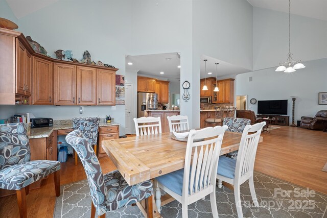 dining area featuring an inviting chandelier, high vaulted ceiling, recessed lighting, and dark wood finished floors