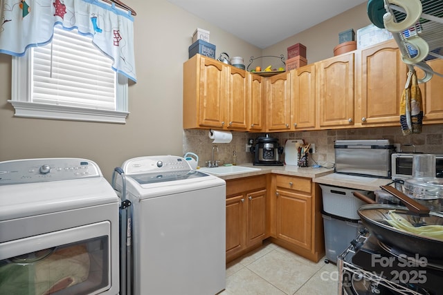laundry room with a sink, light tile patterned floors, plenty of natural light, and laundry area