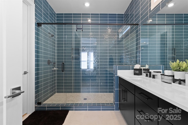 bathroom featuring a shower stall, tile walls, and vanity