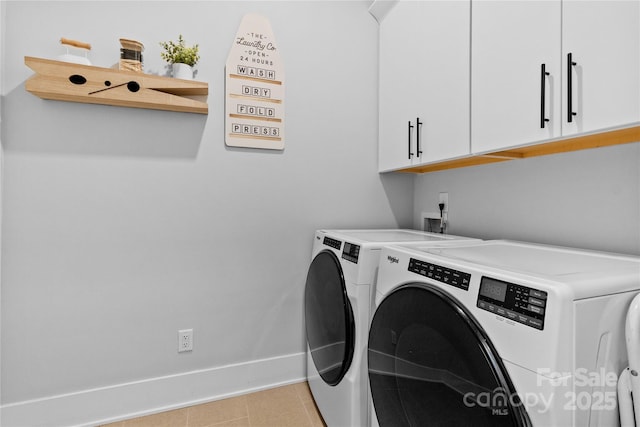 laundry area with cabinet space, light tile patterned flooring, baseboards, and washing machine and clothes dryer