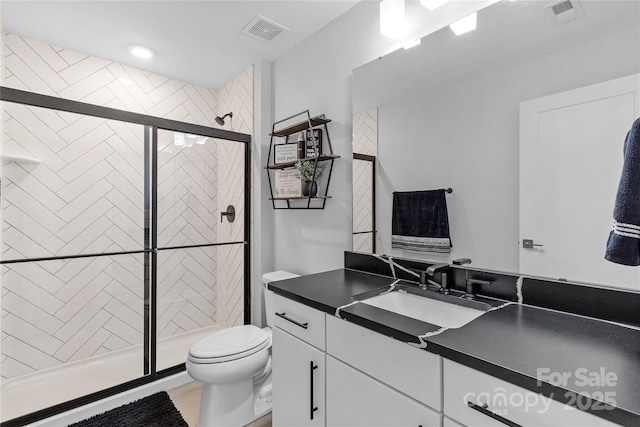 full bathroom featuring a stall shower, visible vents, vanity, and toilet