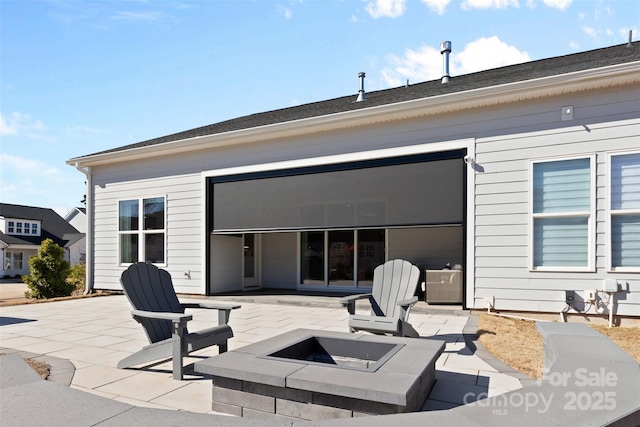 rear view of property with an outdoor fire pit and a patio