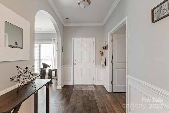 3216 Bridgewick Rd, Waxhaw, NC 28173 - foyer entrance featuring arched walkways, dark wood finished floors, crown molding, and wainscoting