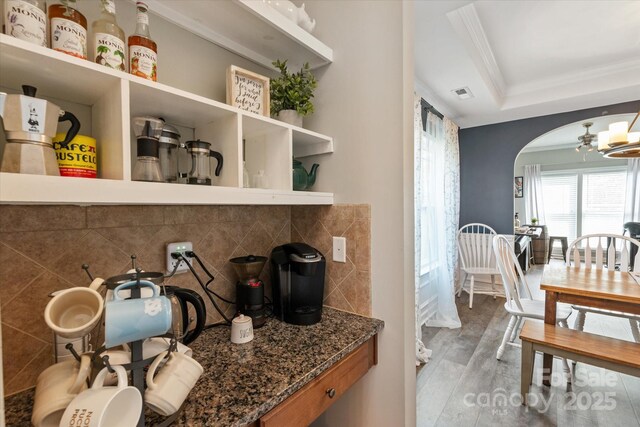 3216 Bridgewick Rd, Waxhaw, NC 28173 - interior space featuring wood finished floors, visible vents, ornamental molding, arched walkways, and tasteful backsplash