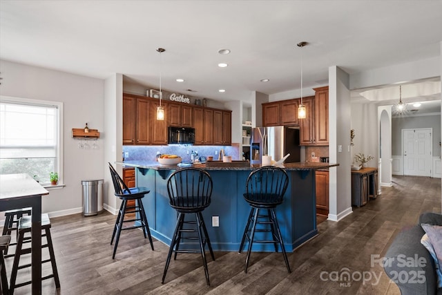 3216 Bridgewick Rd, Waxhaw, NC 28173 - kitchen with arched walkways, stainless steel fridge, black microwave, and brown cabinetry