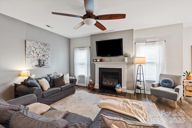 3216 Bridgewick Rd, Waxhaw, NC 28173 - living room featuring a ceiling fan, wood finished floors, a fireplace with flush hearth, baseboards, and visible vents