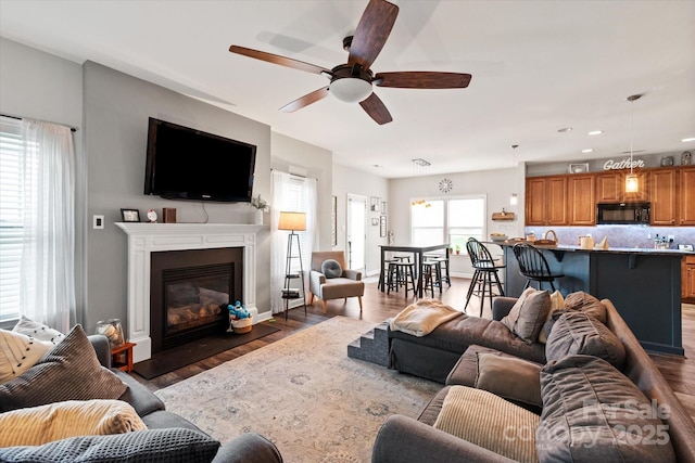 3216 Bridgewick Rd, Waxhaw, NC 28173 - living area with recessed lighting, a glass covered fireplace, wood finished floors, and a ceiling fan
