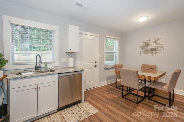 kitchen featuring white cabinetry, sink, light stone counters, and stainless steel dishwasher