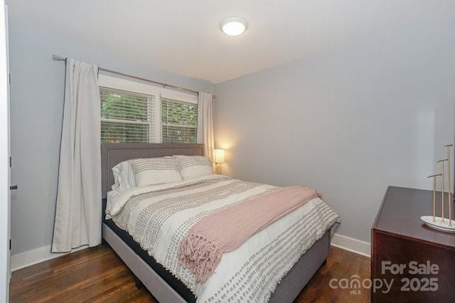 bedroom with dark hardwood / wood-style floors