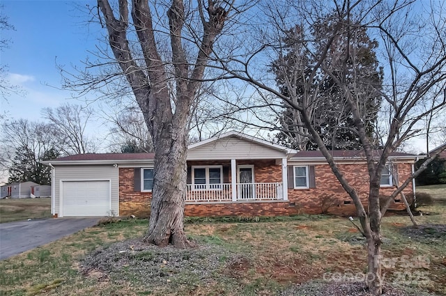 ranch-style home with a porch, a garage, brick siding, driveway, and crawl space