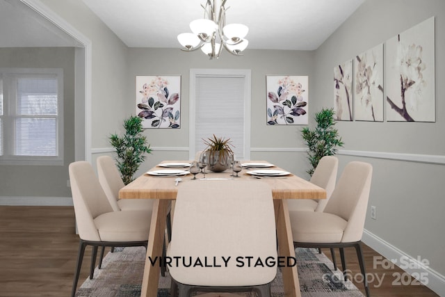 dining area with a chandelier, dark wood finished floors, and baseboards