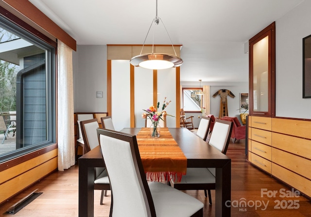 dining space with visible vents, plenty of natural light, and wood finished floors