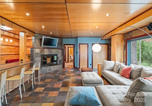 living room featuring a multi sided fireplace, recessed lighting, wooden ceiling, and stone finish floor