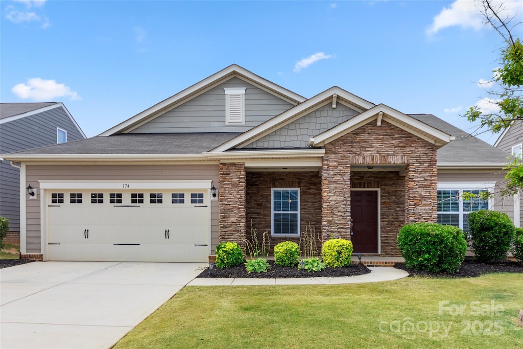 craftsman inspired home featuring a garage and a front yard