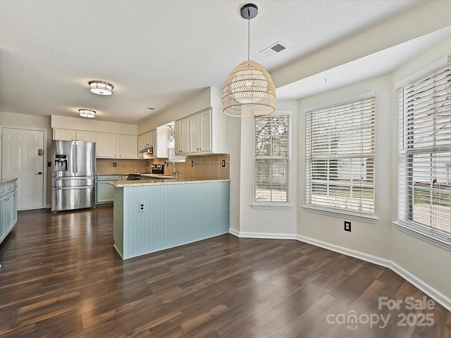 kitchen with visible vents, white cabinets, stainless steel refrigerator with ice dispenser, dark wood finished floors, and pendant lighting